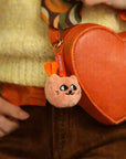 Mini peluche porte-clés Mewchi Sweet Buddies OMY accrochée à un sac orange