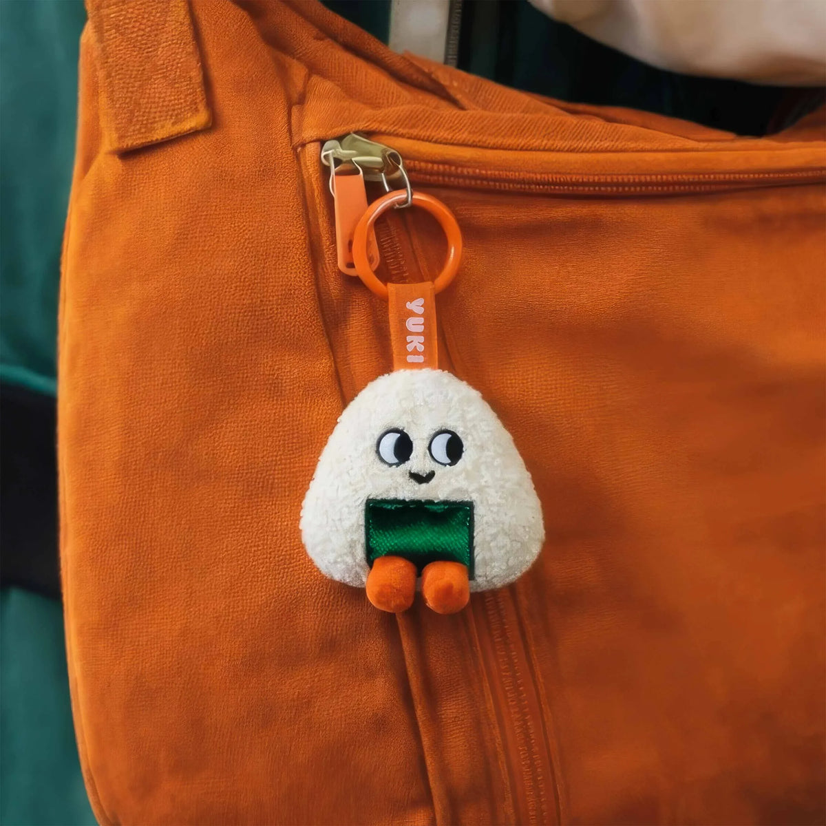 Mini peluche porte-clés Yuki Sweet Buddies OMY accrochée à un sac orange