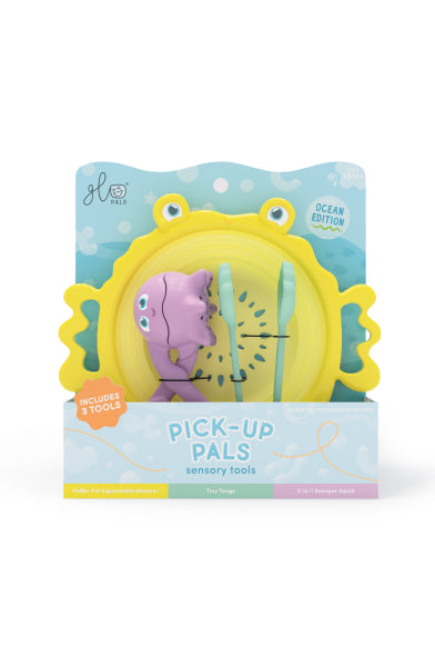Set d’outils sensoriels Glo Pals dans son emballage, avec passoire jaune en forme de crabe, outil violet et pince vert menthe.